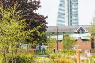 People walking through the planting and trees at Meadow Lane