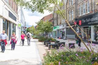The main high treet in Altrincham which has new SuDS and seating blocks, as shoppers pass by.