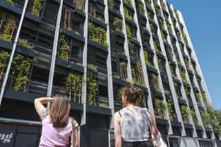 In image of two women looking up at the new Mobility Hub in Ancoats