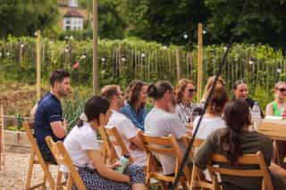 An image of people all gathered sitting on deck chairs, smiling as they listen to someone not pictured