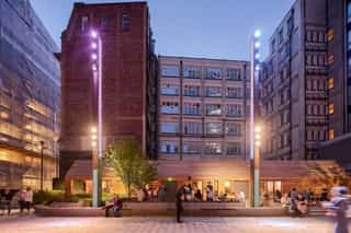 Dusk shot of The Pilcrow in Sadler's Yard with people sat outside enjoyign a drink.