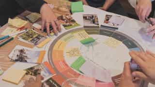 Planit's Regenerative Design Tool being used at a workshop across a table.