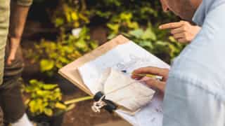 An image of someone using a clipboard to look over a plan