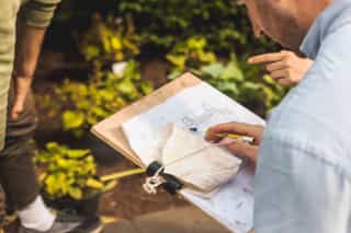 An image of someone using a clipboard to look over a plan