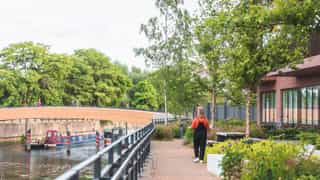 An image of a woman walking along a canal at Sugar House Island