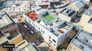 A birds eye view of School 360 in Sugar House Island, showing the playing field and various spaces available on the rooftop